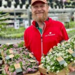 Smilende gartner med spiselige blomster hos Lier Planteland